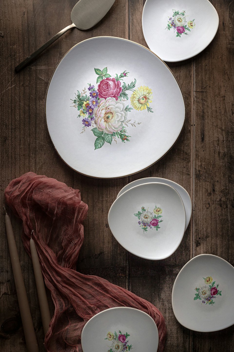 Ceramic plates with floral designs on a rustic wooden surface.